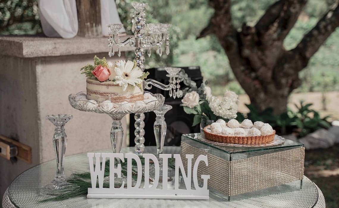 Blumendeko Hochzeitstorte mit Naked Cake, frischen Blumen und eleganter Präsentation im Außenbereich