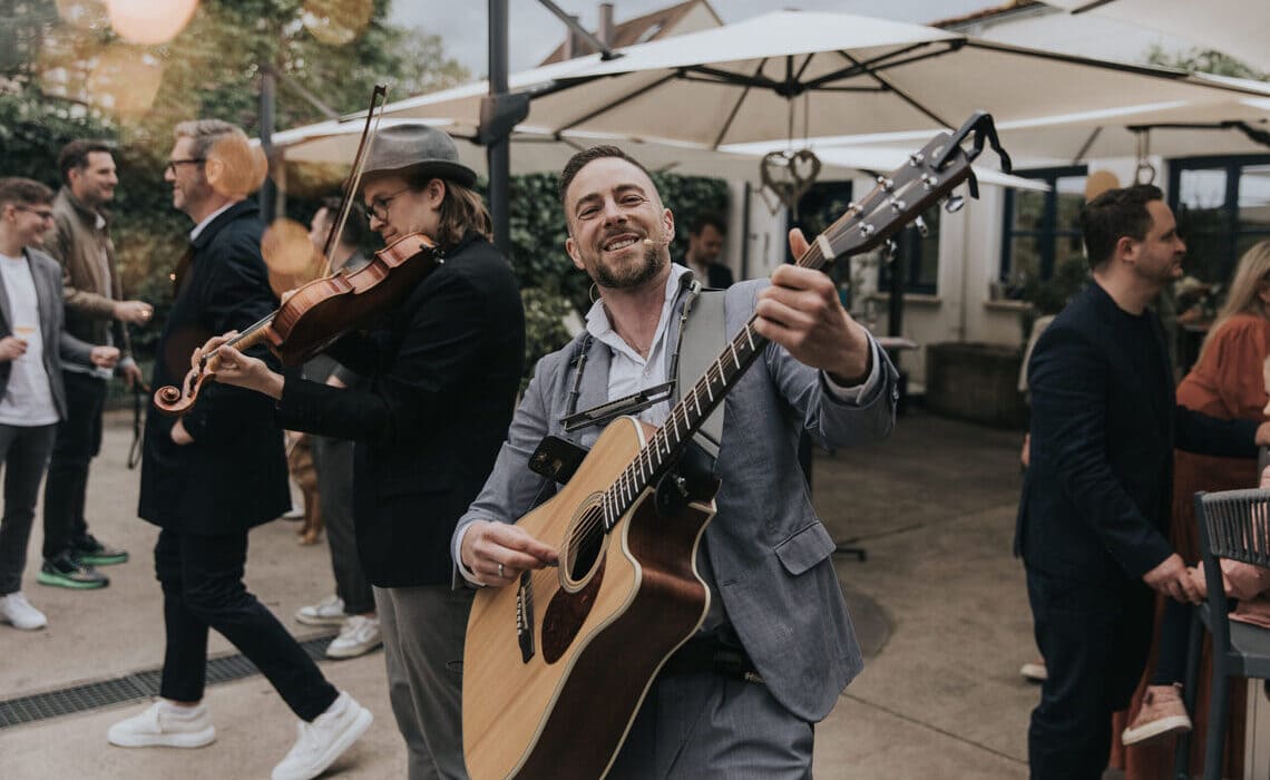 Live-Band mit Gitarre und Geige sorgt für Stimmung auf einer Hochzeit als Beispiel für die Entscheidung zwischen Hochzeits-DJ oder Live-Band