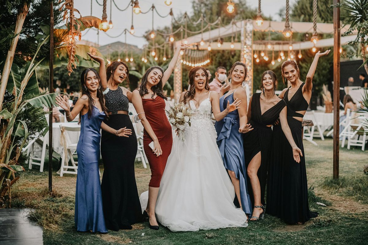 Braut mit Freundinnen bei einer fröhlichen Feier unter Lichterketten