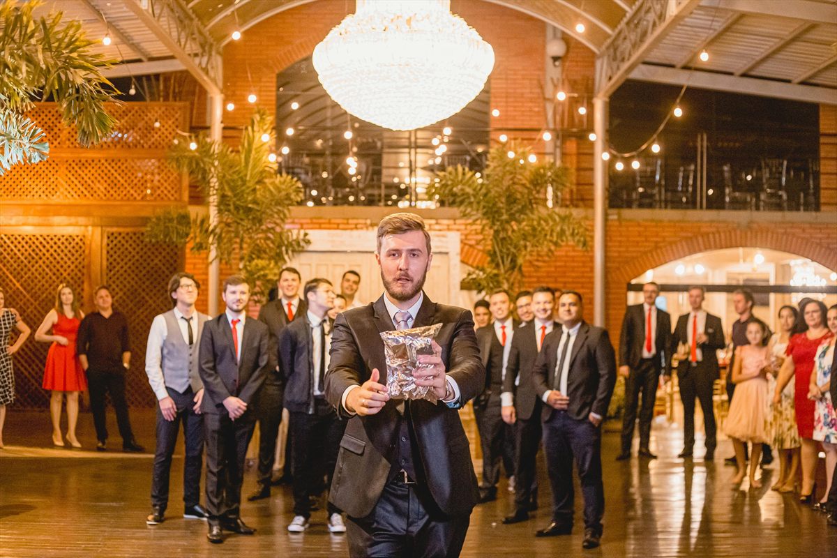 Hochzeitsgast wirft bei einem Hochzeitsspiel ein Päckchen zu anderen Gästen