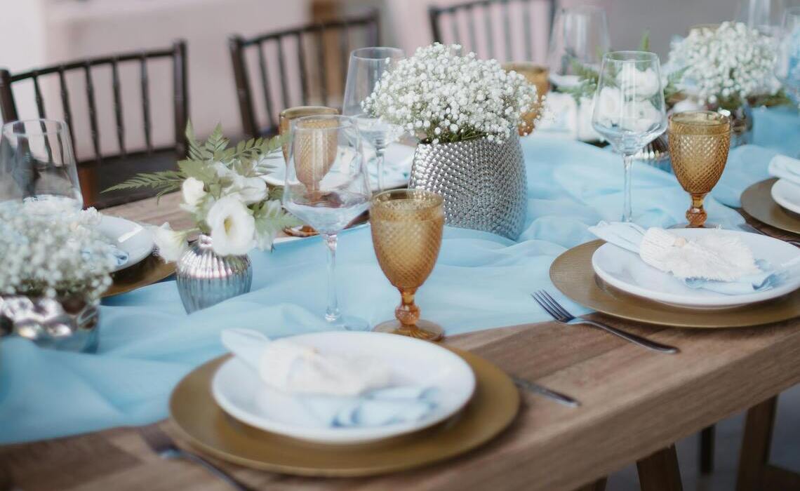 Schleierkraut als Hochzeitsdeko auf festlich gedecktem Tisch mit Glasvasen und goldenen Akzenten